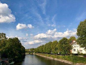 River amidst trees and buildings against sky