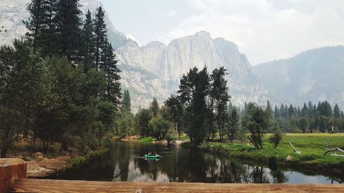 Scenic view of lake in forest against sky