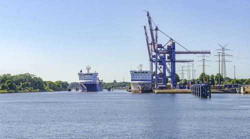Commercial dock by sea against clear sky