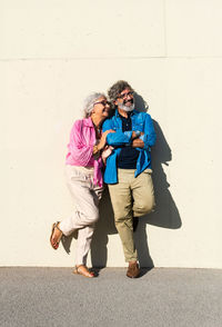 Full length of woman standing against wall