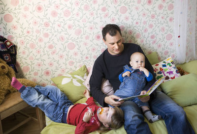 Mother reading book to his children