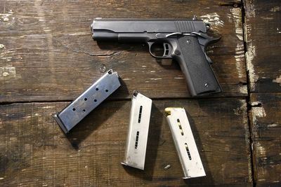 High angle view of bullets and handgun on table