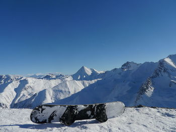 Close-up of ski on snow with mountain range in background