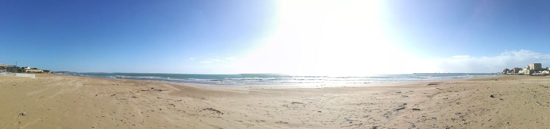 Panoramic view of beach against blue sky