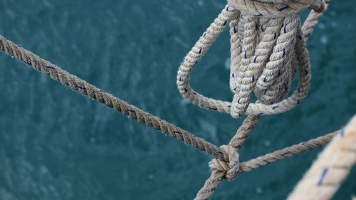 Close-up of rope tied on bollard against sea