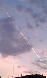 Low angle view of vapor trails against sky during sunset