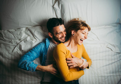 Young couple kissing on bed at home