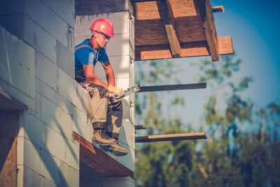 Low angle view of worker sitting at construction site