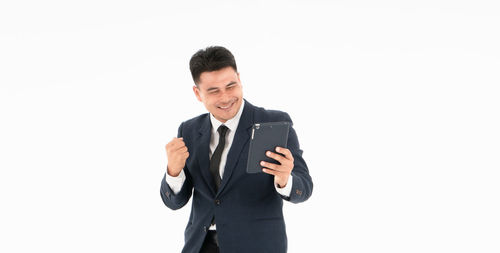 Man with arms raised standing against white background