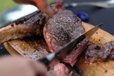 Close-up of person preparing food on barbecue grill