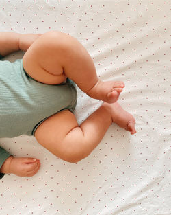 Low section of woman lying on bed