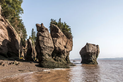 Rock formation on beach against clear sky