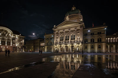 Reflection of illuminated buildings in city at night