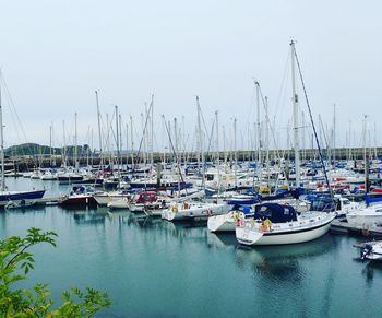 Boats moored in calm lake against clear sky