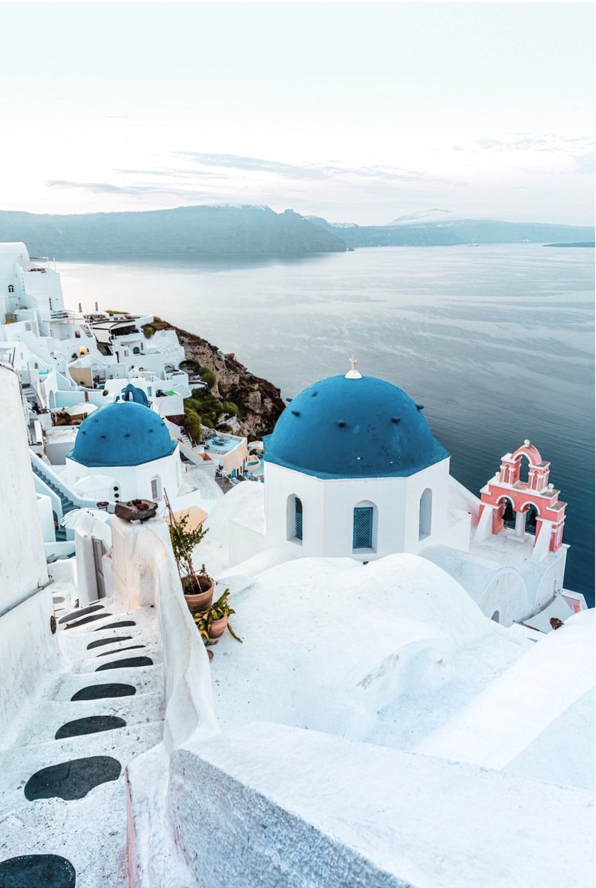 HIGH ANGLE VIEW OF WHITE BUILDING BY SEA