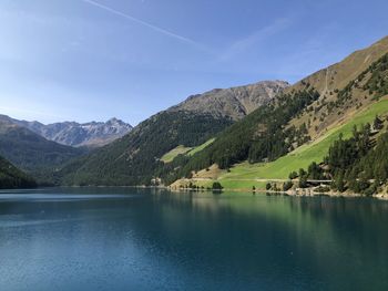 Scenic view of lake and mountains against blue sky