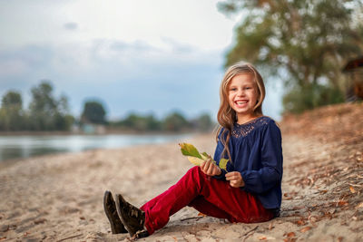 Portrait of smiling girl sitting on tree