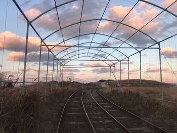 Railroad tracks on field against sky