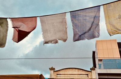 Low angle view of clothes drying on building against sky