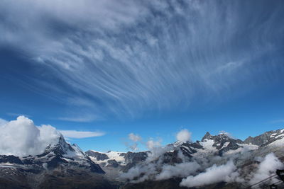 Scenic view of snowcapped mountains against blue sky