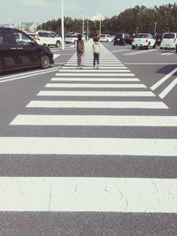 Low section of people walking on city street