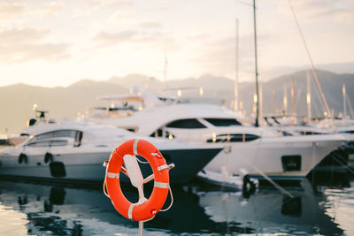 Boats moored at harbor during sunset