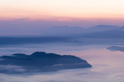 Scenic view of silhouette mountain against dramatic sky during sunset