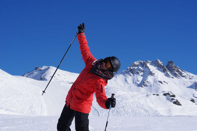 Rear view of woman on snowcapped mountain against clear sky