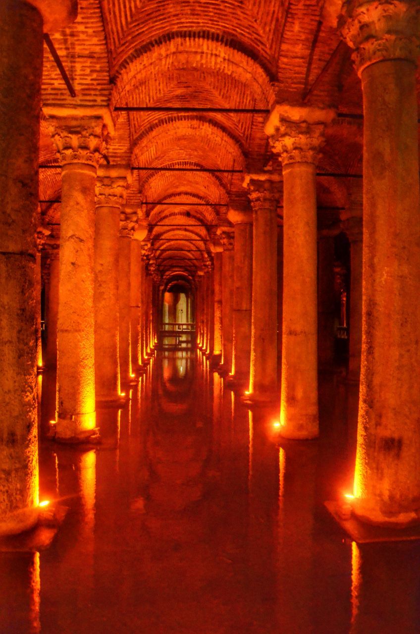 indoors, arch, architecture, built structure, architectural column, the way forward, corridor, religion, illuminated, place of worship, history, column, diminishing perspective, in a row, spirituality, colonnade, orange color, church, interior, travel destinations