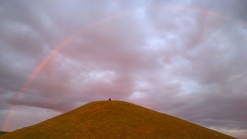 Low angle view of rainbow against sky during sunset