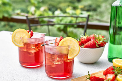 Fresh summer strawberry cocktail or mocktail on the table in garden. sparkling strawberry lemonade.