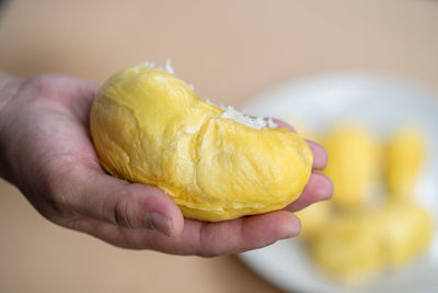 Close-up of hand holding yellow lemon