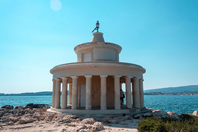 Built structure on beach against clear blue sky