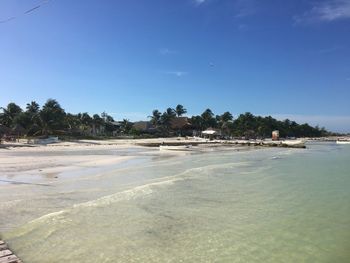 Scenic view of beach against clear blue sky