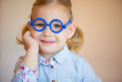 Portrait of smiling girl sitting by chessboard at home