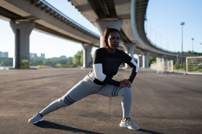 Black woman warming up during running training