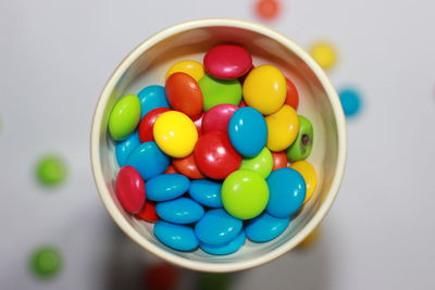 High angle view of multi colored candies in bowl on table