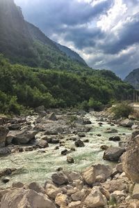 Scenic view of river by mountains against sky