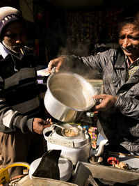 Men preparing tea at market stall