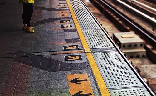 Low section of people standing on tiled floor