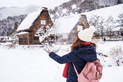 Rear view of woman standing on snow field
