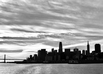 River by city buildings against sky