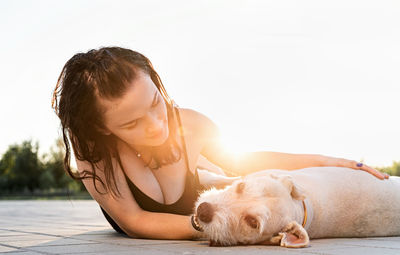 Woman with dog lying down against white background