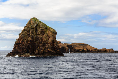 Rock formations in sea against sky