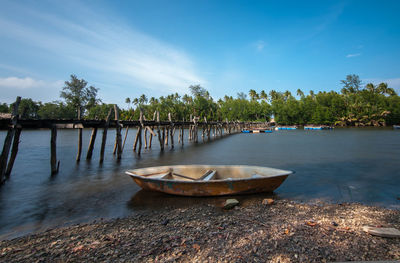 Boat moored on river against sky