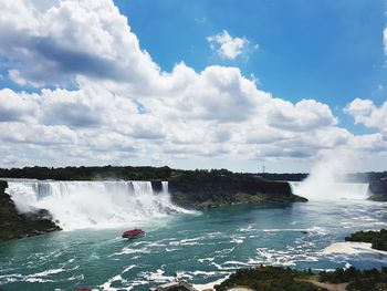 View of waterfall against cloudy sky