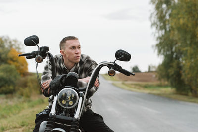 Portrait of man riding motorcycle on road