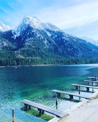 Scenic view of lake by snowcapped mountains against sky