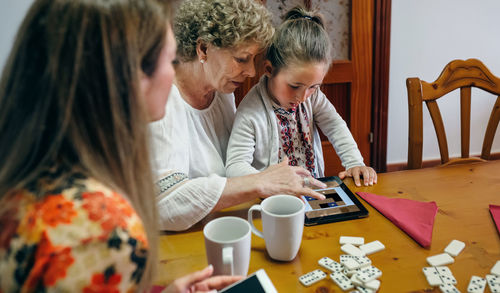 Close-up of family using digital tablet at table