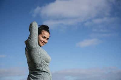 Woman stretching and looking at camera